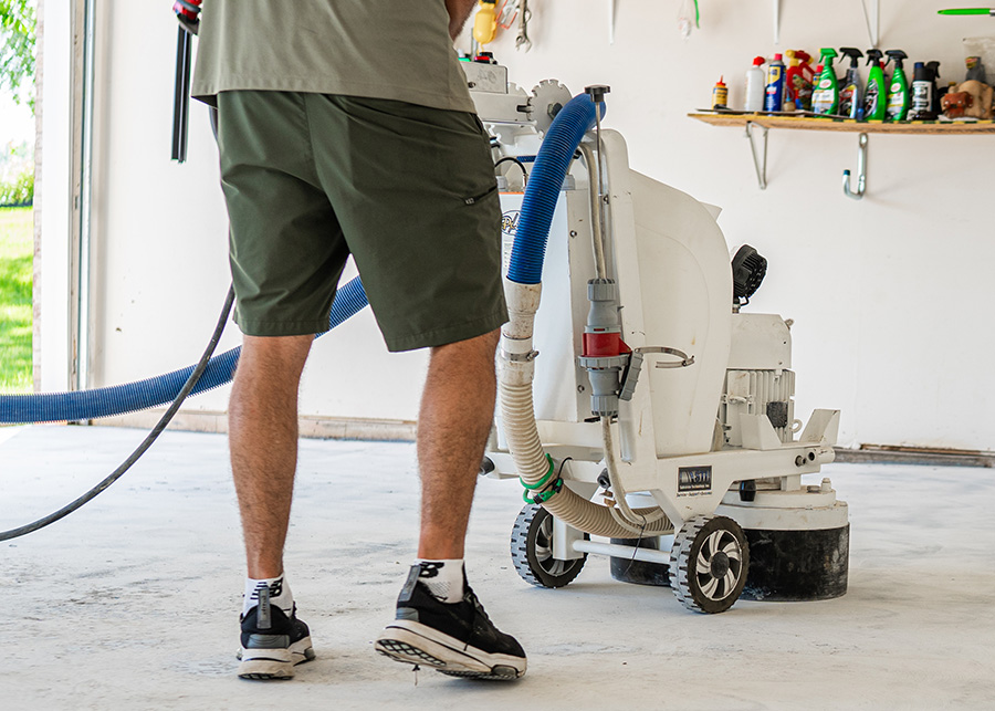 Bronco Contracting technician installing a premium garage epoxy and polyaspartic floor coating in Rockford, IL for a durable residential garage floor.